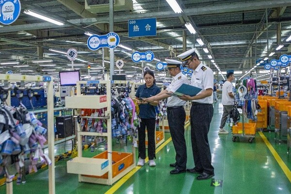 Customs officers in Huaibei, east China's Anhui province visit a local electronics company to offer guidance on customs affairs. (Photo by Xiao Benxiang/People's Daily)