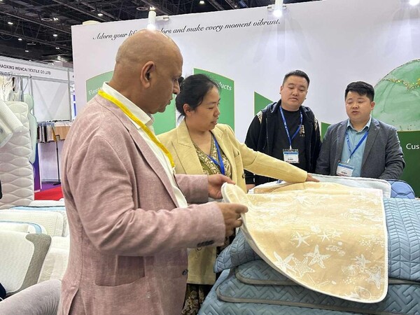 A business representative from the Textile Merchants Group experience Chinese textile products. (By Ren Haoyu/People's Daily)