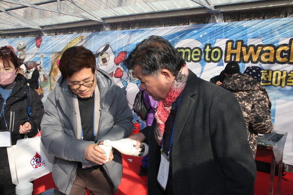 President Kim Hyung-dae of The Korea Post media (left), who organized the tour that day is getting a cup of Makkeolli rice wine from an ambassador.