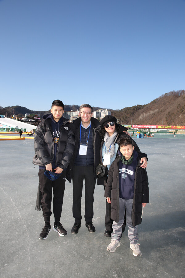 Counselor of Uzbekistan (2nd from left) wears a big smile on the surface of ice with his family members.