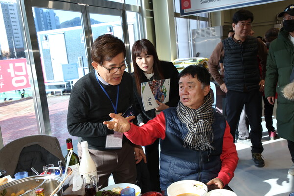  Mayor Cho Moon-soon (seated at right) explains to President Kim Hyung-dae about the schedule of the day for the tour of the ambassadors and other diplomats.