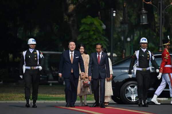 President Yoon Seok-yul of Korea (2nd from left) walk with Indonesian President Joko Widodo (3rd from left) as they arrive for an official welcome ceremony at the Presidential Palace in Jakarta on Sept. 8, 2023.. The first ladies of the two leaders are seem following behind them.
