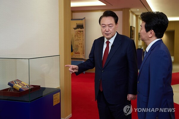 President Yoon Suk Yeol (L) introduces a compilation of Winston Churchill's speeches, gifted by King Charles III during a state visit to Britain in November 2023, to a KBS anchorman after recording a special interview with the state-run broadcaster at the presidential office in Seoul on Feb. 4, 2024, in this photo provided by the office.  (Yonhap)
