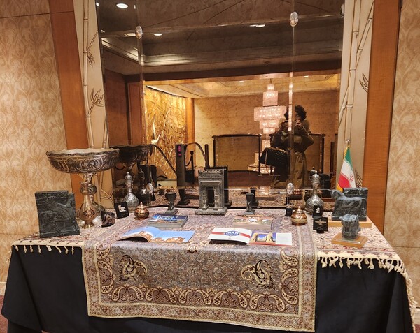 Traditional Iranian art works and books on display on the table at the venue of the Iranian reception.