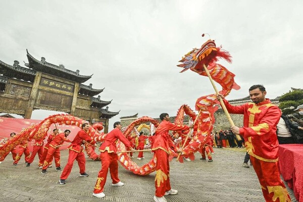 Foreign students from Nanchang University perform a dragon dance in a historical block in Fuzhou, east China's Jiangxi province, Feb. 13, 2024. (Photo by Li Jie/People's Daily Online)