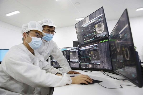 Two employees check production data at the data control center of a silicon materials technology company in east China's Jiangsu province. (By Cai Guangyin/People's Daily Online)