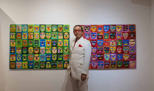 Artist Zion Khan poses with his works.