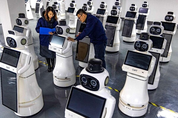 Technicians debug reception robots in a workshop of a tech firm in Zhangye, northwest China's Gansu province. (Photo by Yang Xiao/People's Daily Online)