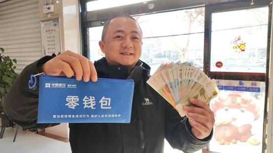 A merchant showcases a "change pack" provided by the Xinxiang branch of Zhongyuan Bank. (Photo courtesy of Xinxiang Daily)