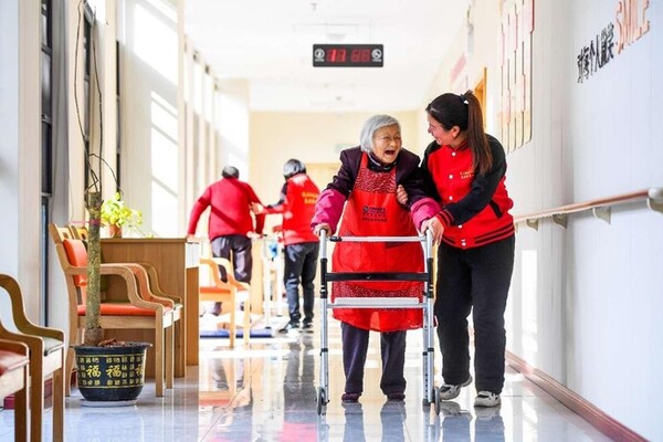 A staff member talks to a senior in an elderly care center in Yuanshan community, Yichun, east China's Jiangxi province. (Photo by Zhou Liang/People's Daily Online)