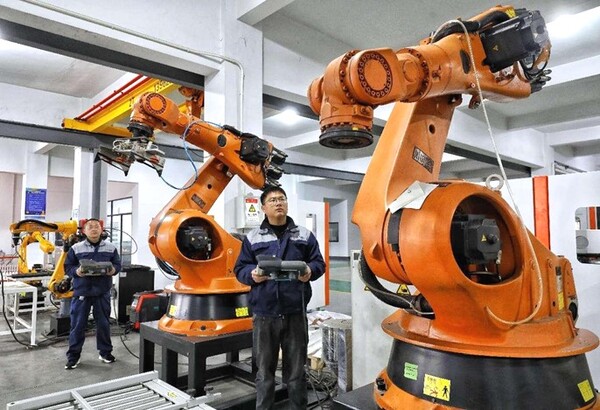 Technicians debug robots in a workshop of a robot manufacturer in Fenghuang township, Zhangjiagang, east China's Jiangsu province. (Photo by Shi Bairong/People's Daily Online)