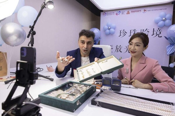 Two hosts sell jewelry via cross-border livestream at a jewelry store in Zhuji, east China's Zhejiang province. (Photo by Guo Bin/People's Daily Online)