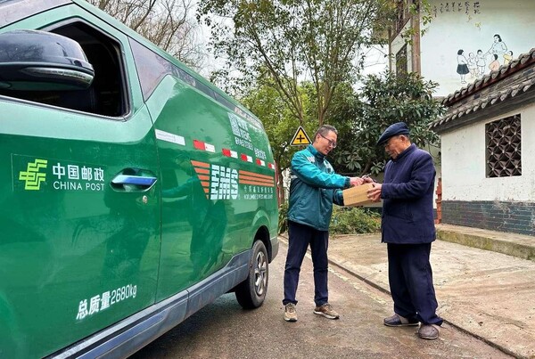 A courier sends a parcel to a resident in Shuili community, Dahua township, Renshou county, Meishan, southwest China's Sichuan province. (Photo by Pan Shuai/People's Daily Online)