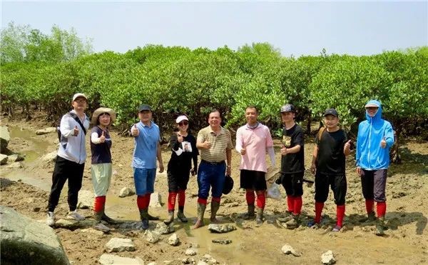 Lu Changyi and his mangrove protection team pose for a picture on wetland during a field trip. (Photo from the official website of Xiamen University)