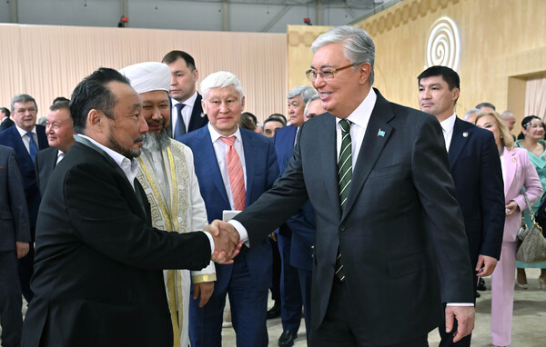 President Tokayev of Kazakhstan (right, foreground) shakes hands with attendees at the National Congress meeting