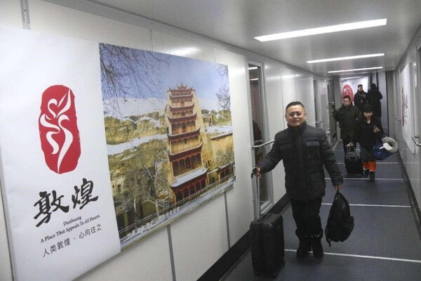 Passengers taking the first chartered tourist flight from Jakarta, Indonesia to Dunhuang, northwest China's Gansu province arrive at the Dunhuang Mogao International Airport, Dec. 24, 2023. (Photo by Zhang Xiaoliang/People's Daily Online)