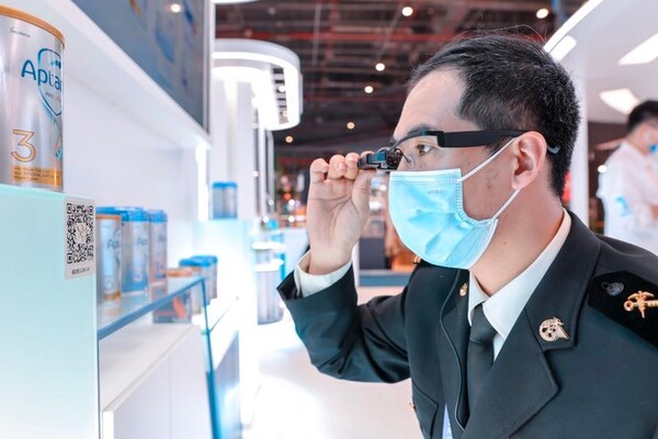 The Shanghai Customs for the first time launched inspection for exhibition halls and exhibits with new technologies such as augmented reality (AR) goggles and digital tags during the fourth China International Import Expo in 2021. Photo shows a customs officer checking the information of a milk powder product with AR goggles. (Photo from the official account of the publicity department of the Pudong New Area of Shanghai on WeChat)