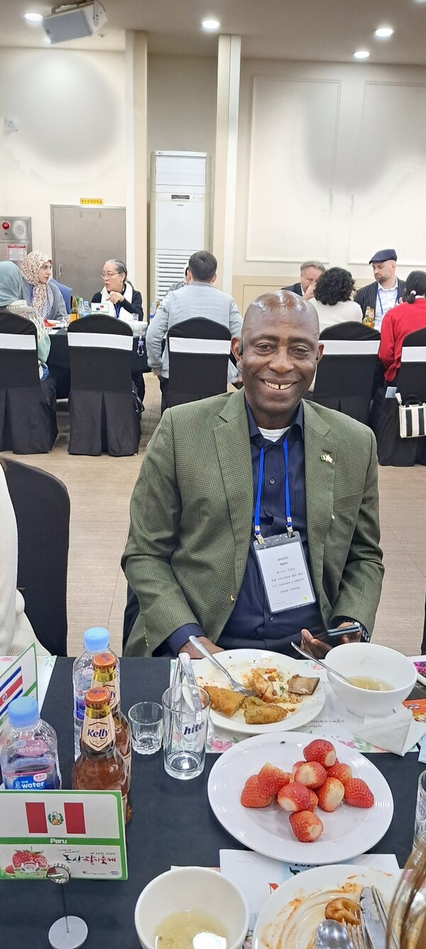 Ambassador Ferdinand o. Nwonye of Nigeria is all smiles with some juicy strawberries and food on his table.