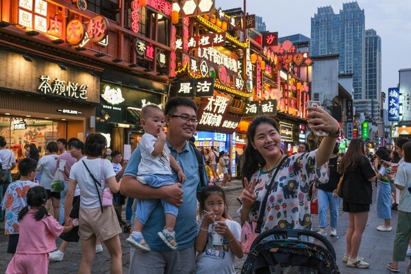 Tourists pose for a picture in the Taiping Street, Changsha, central China's Hunan province. (Photo by Lin Daohui/People's Daily Online)