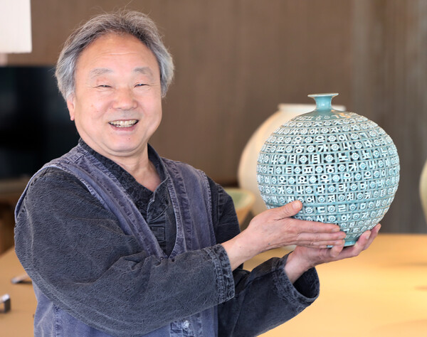 A master pottery maker shows off his ceramics using the alphabet of the Korean alphabet