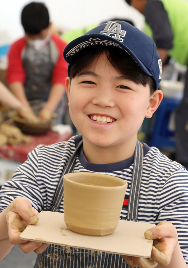                                 Smiling as he shows off his moulded clay creations
