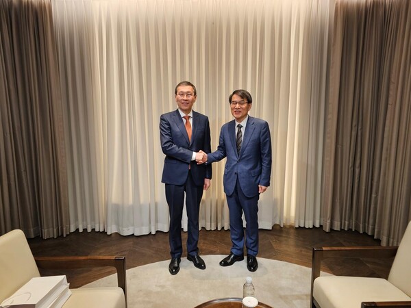 . Nurlan Abdirov, Chairman of the Central Election Commission of Kazakhstan, and Roh Tae-ak, Chairman of the National Election Commission of the Republic of Korea, shake hands.
