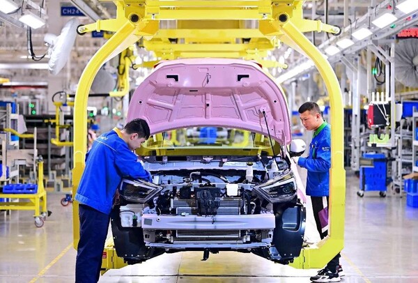 A pure electric vehicle is assembled on a smart production line in a workshop of a new energy vehicle company in Nanchang, east China's Jiangxi province. (Photo by Zhu Haipeng/People's Daily Online)