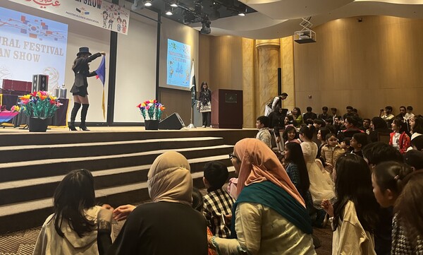 Attendees watch a magic performance. (Source: The Korea Post)