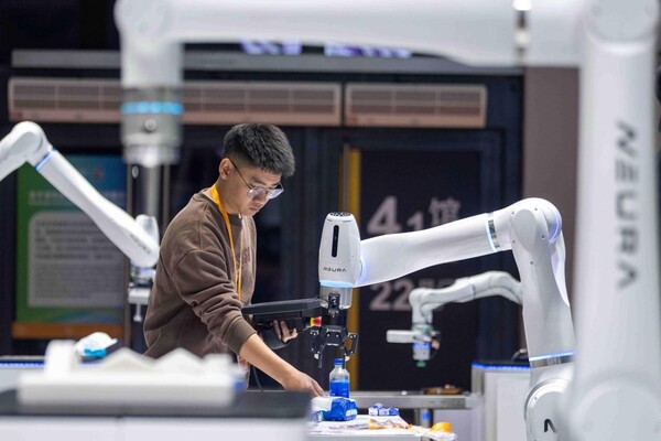A staff member tests robotic arms to be exhibited at the technical equipment exhibition area of the 8th China International Import Expo, Nov, 3. (Photo/Weng Qiyu)